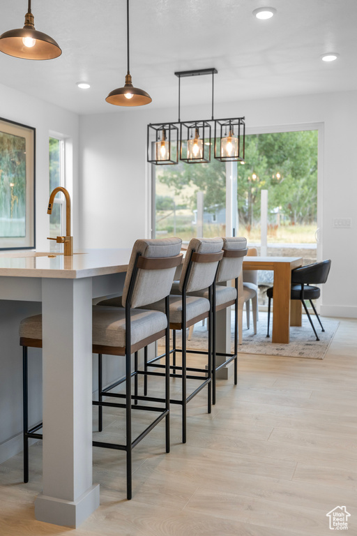 Dining room with light wood-style flooring, recessed lighting, and baseboards