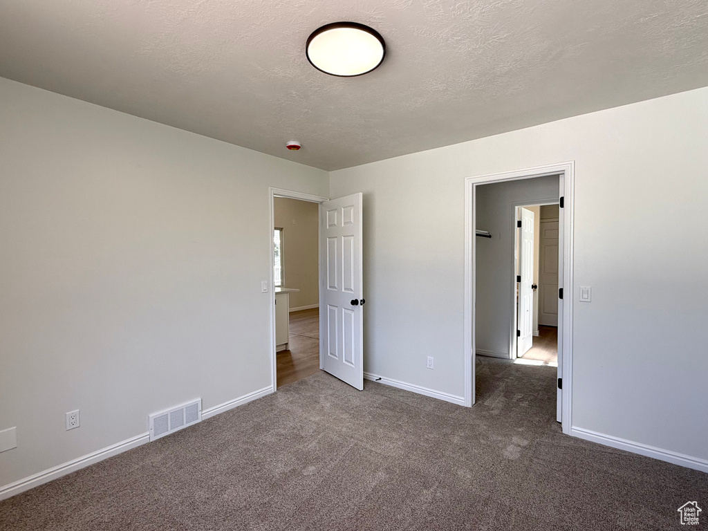 Unfurnished bedroom with carpet flooring and baseboards