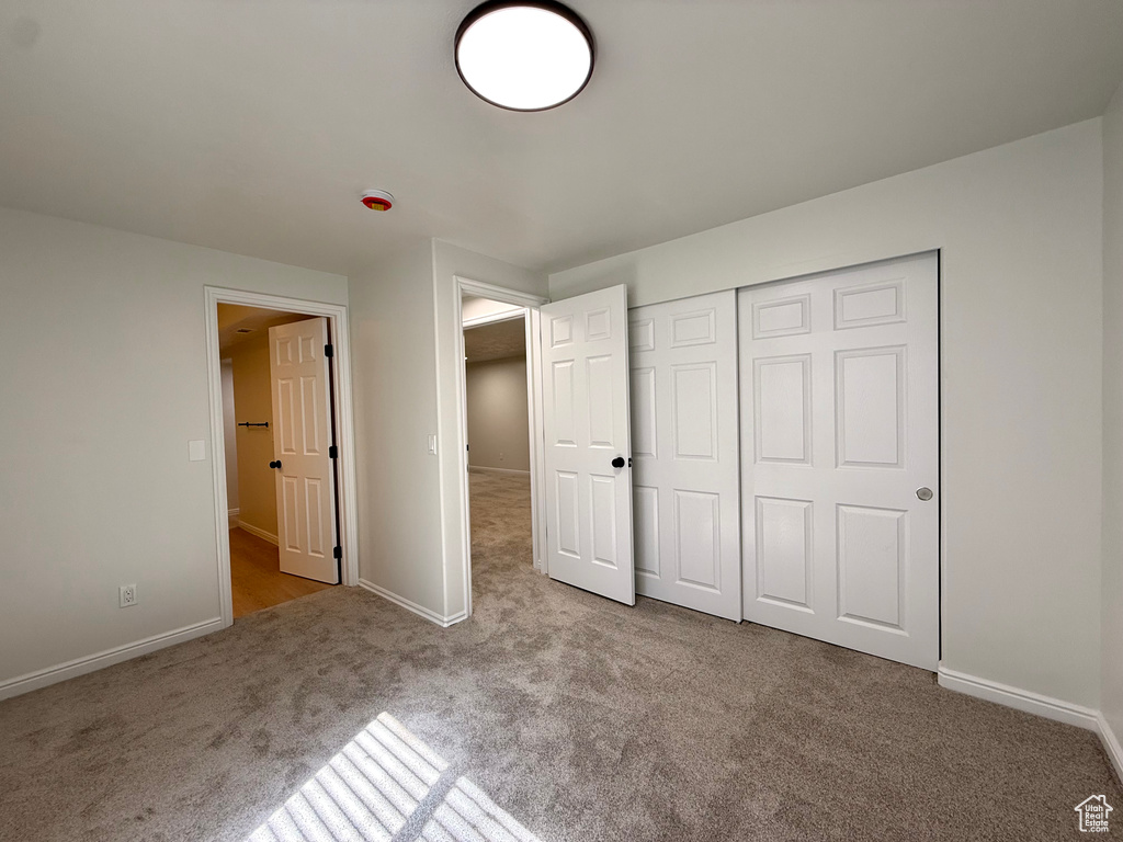 Unfurnished bedroom with carpet flooring, baseboards, and a closet