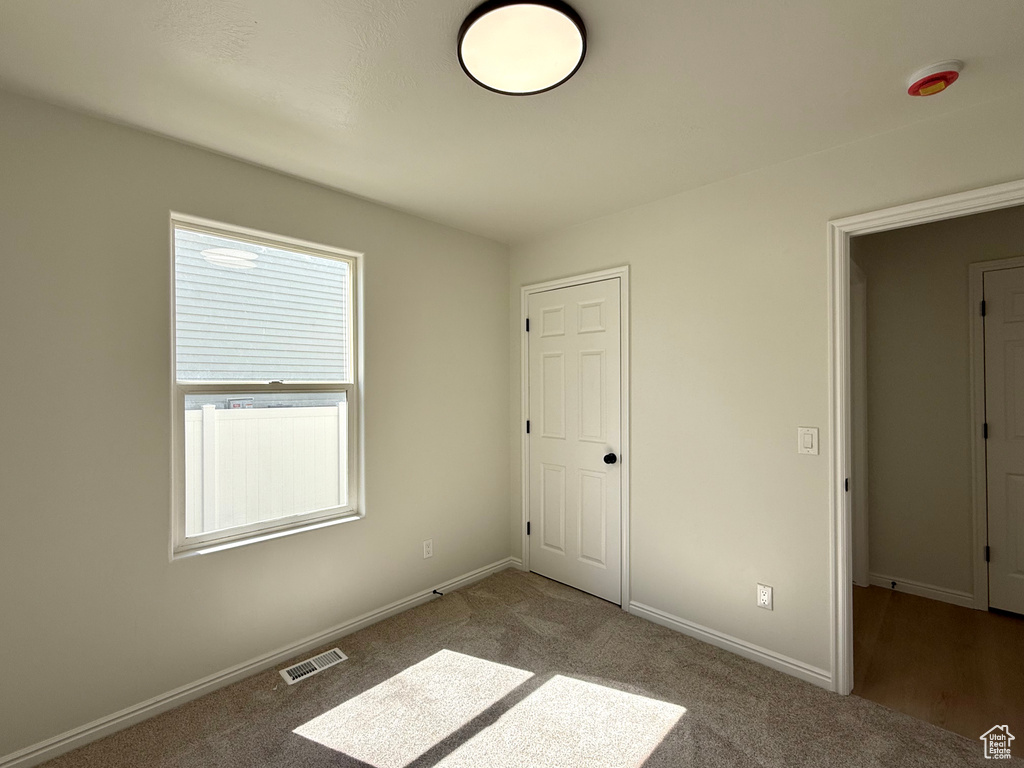 Unfurnished bedroom with carpet and baseboards