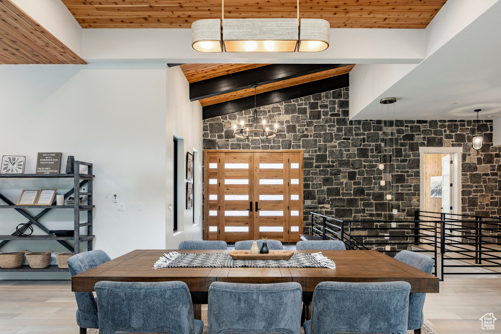 Dining room with wood finished floors, wooden ceiling, and a chandelier