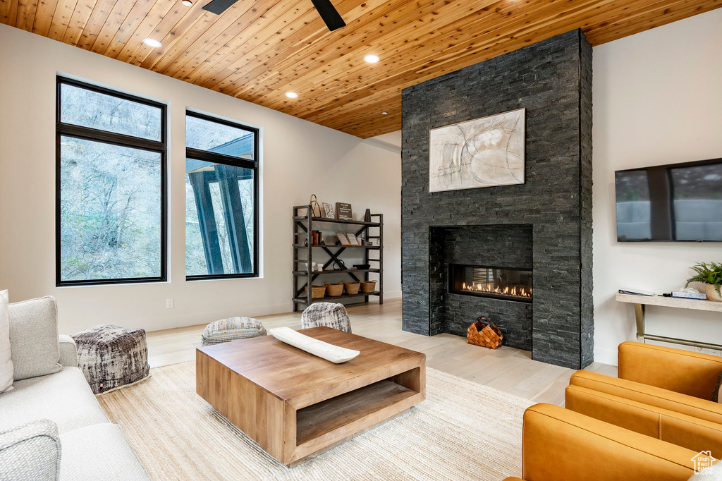Living area with recessed lighting, wood ceiling, wood finished floors, a stone fireplace, and ceiling fan