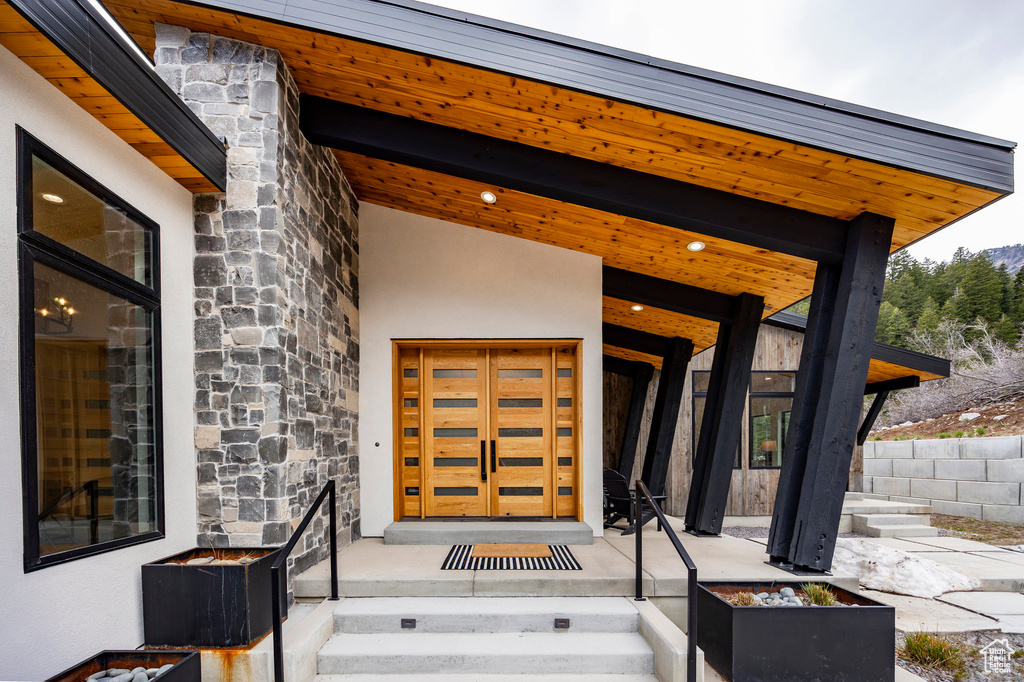 Doorway to property with stone siding and stucco siding
