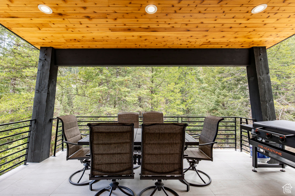 View of patio / terrace with area for grilling, a forest view, and outdoor dining area