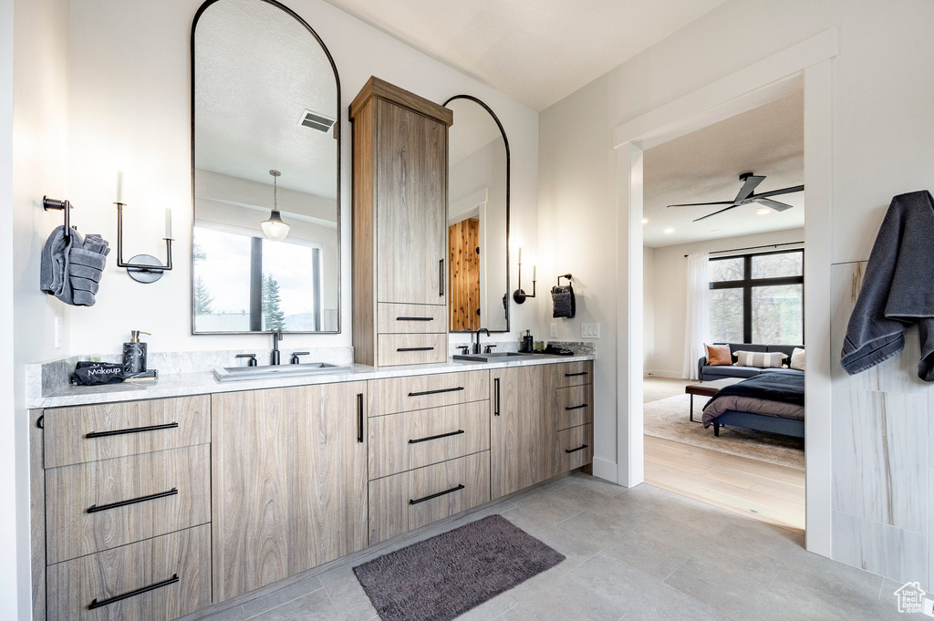 Bathroom with a ceiling fan, double vanity, ensuite bathroom, and tile patterned floors
