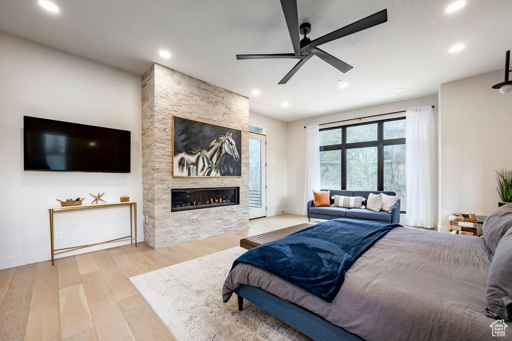 Bedroom featuring a fireplace, wood-type flooring, recessed lighting, baseboards, and ceiling fan