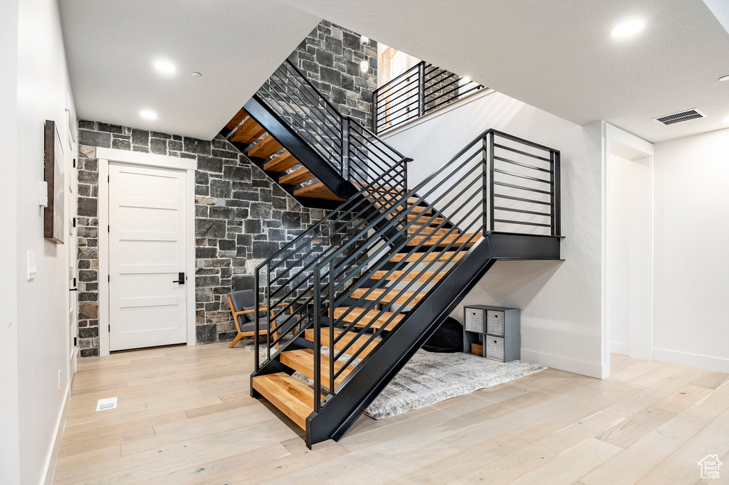 Stairway with baseboards, wood finished floors, and recessed lighting