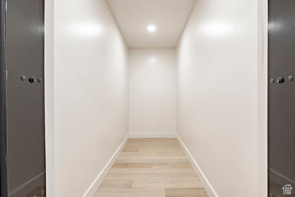 Detailed view of wood finished floors, baseboards, and recessed lighting