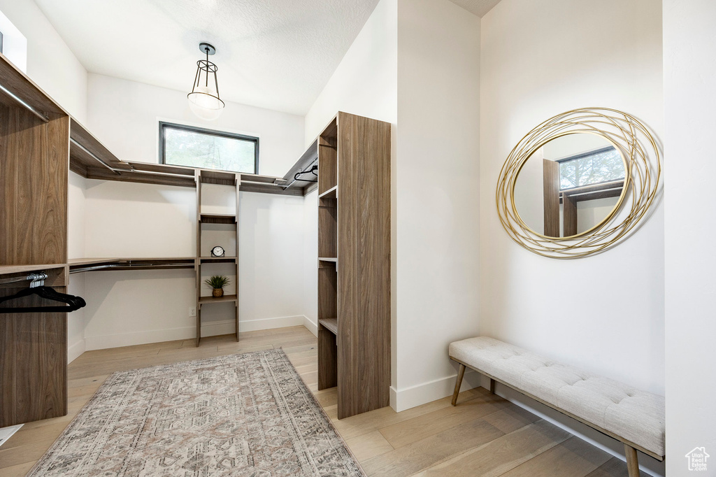 Walk in closet with light wood finished floors