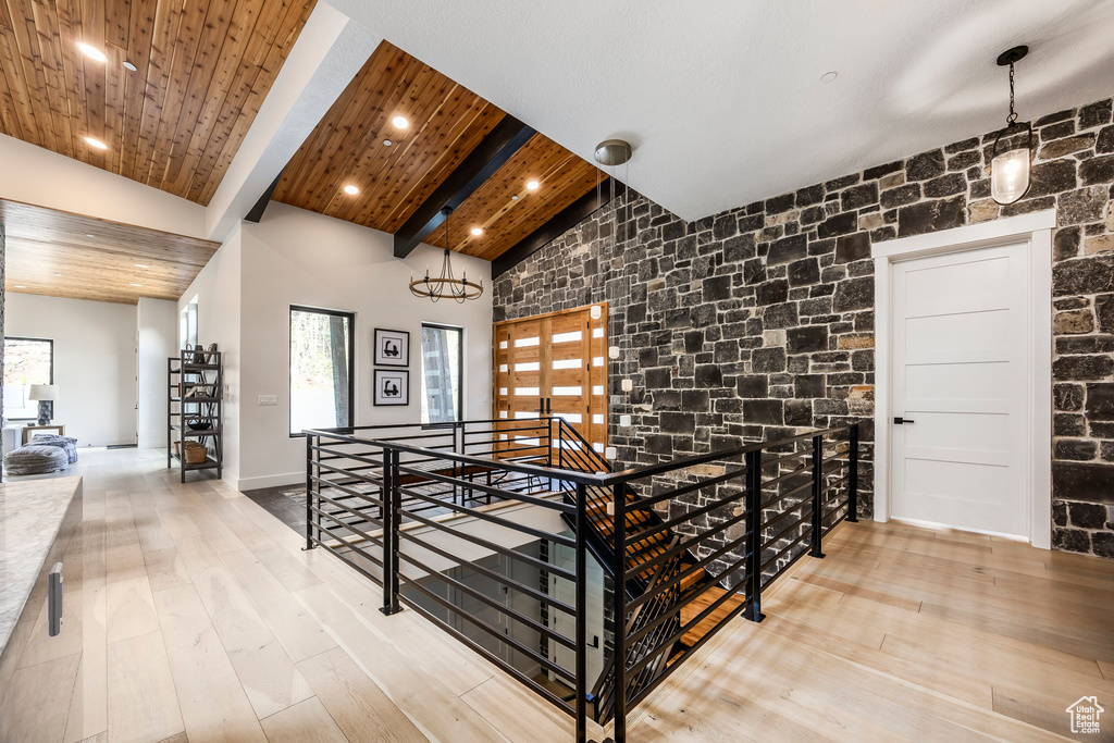 Hallway with an upstairs landing, high vaulted ceiling, wood finished floors, beam ceiling, and recessed lighting