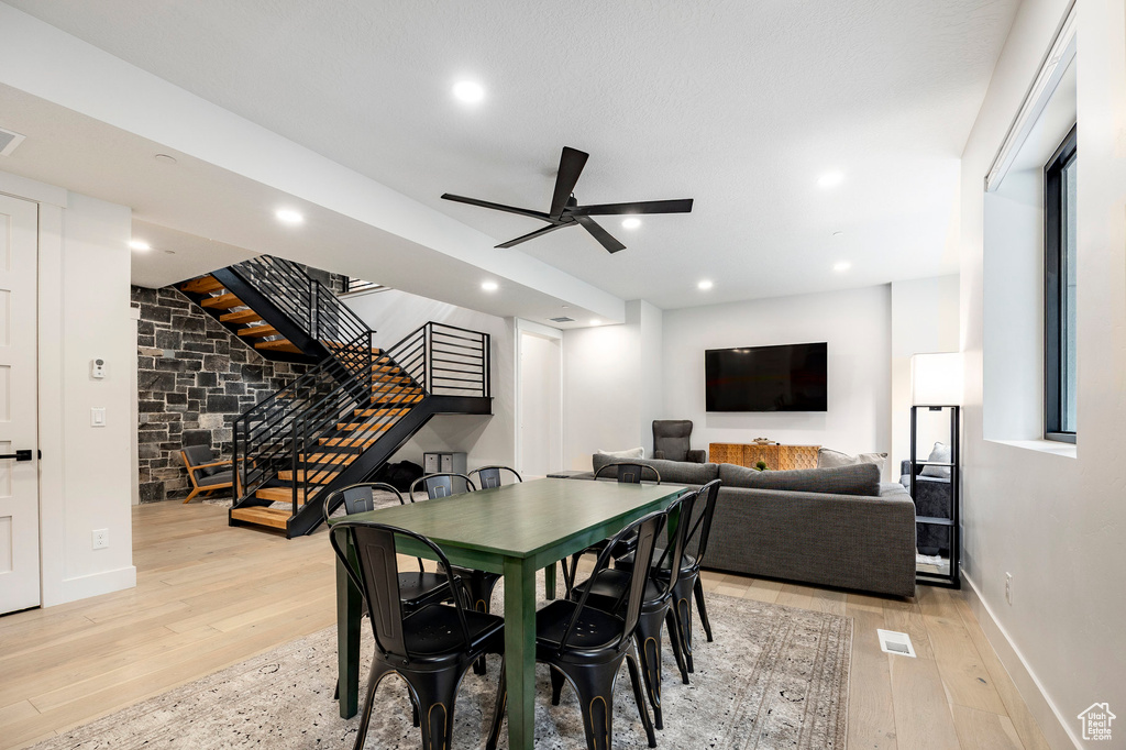 Dining space with stairs, light wood-type flooring, baseboards, a ceiling fan, and recessed lighting