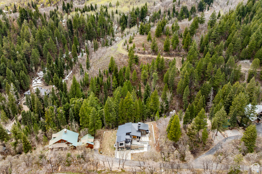 Aerial view of property and surrounding area with a heavily wooded area