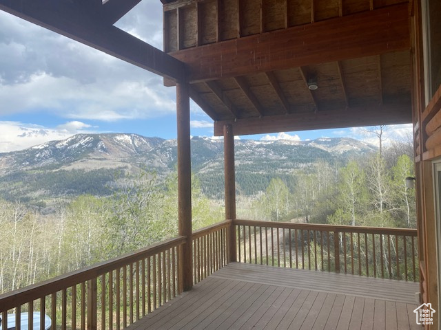 Wooden deck with a mountain view and a forest view