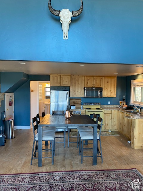 Dining space with hardwood / wood-style floors and baseboards