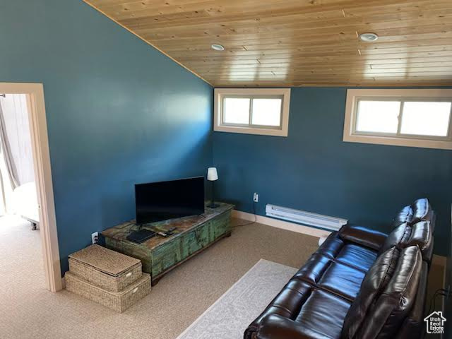 Carpeted living area with wood ceiling, a baseboard heating unit, vaulted ceiling, and baseboards