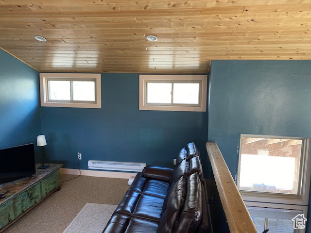 Interior space featuring a baseboard radiator, wooden ceiling, and baseboards