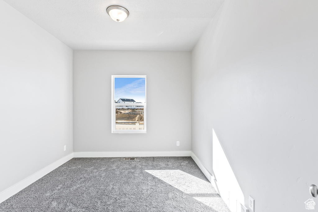 Empty room featuring carpet and baseboards