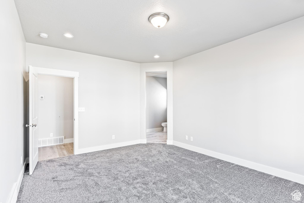 Unfurnished bedroom with light carpet, recessed lighting, and baseboards