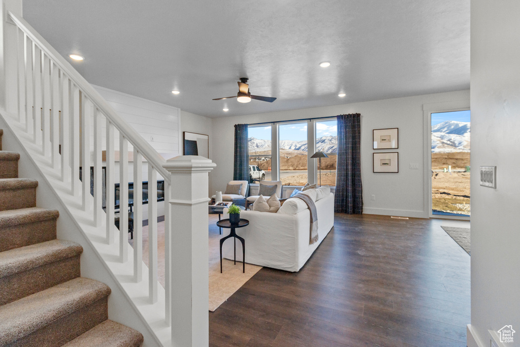 Living room with stairway, recessed lighting, dark wood finished floors, ceiling fan, and baseboards