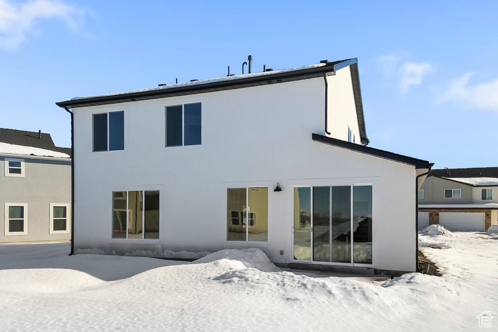 Snow covered property featuring stucco siding