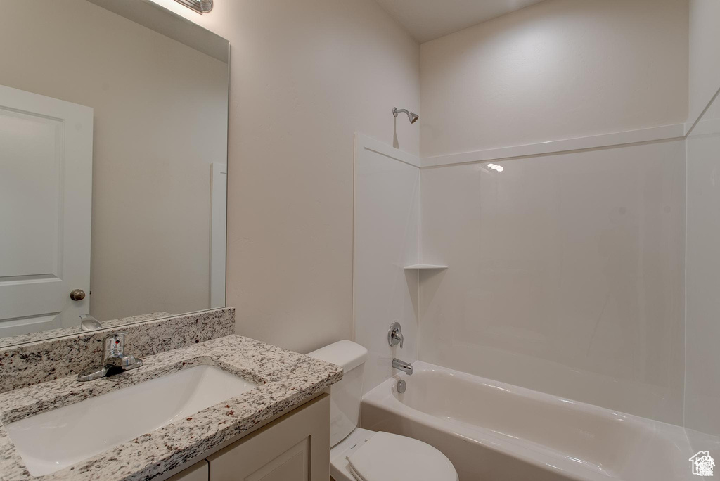 Bathroom featuring tub / shower combination, toilet, and vanity