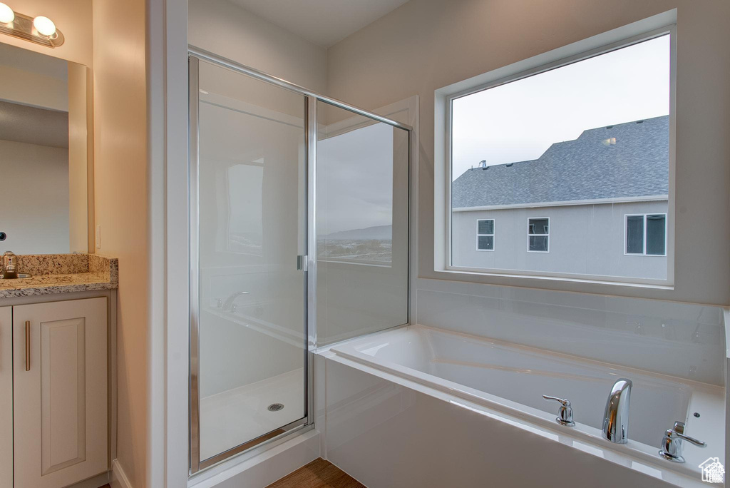 Full bath with a shower stall, a bath, and vanity