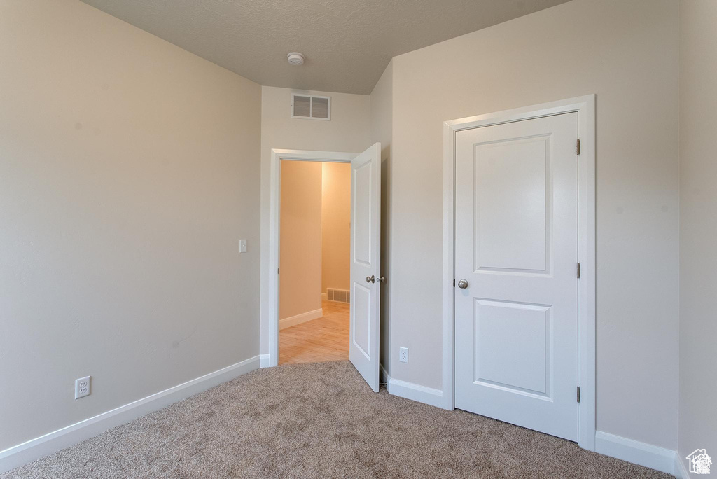 Unfurnished bedroom with carpet floors and baseboards