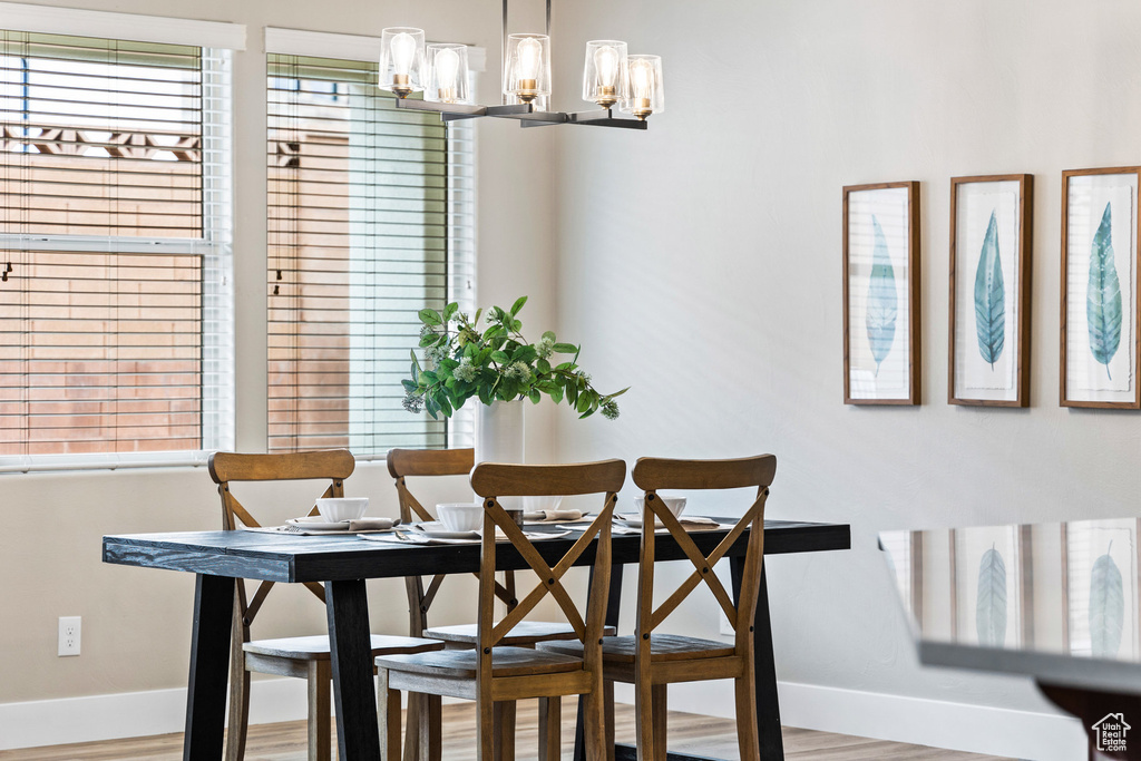 Dining area featuring baseboards, wood finished floors, and a chandelier