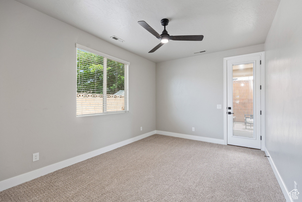 Empty room with carpet flooring, baseboards, and a ceiling fan