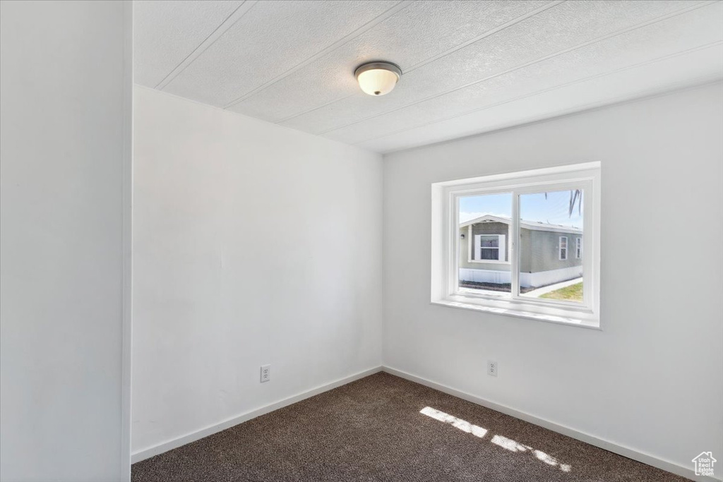 Carpeted empty room with baseboards and a textured ceiling