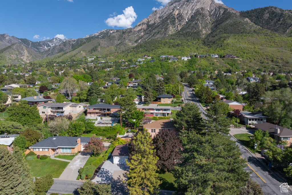 Aerial view of property and surrounding area featuring a mountainous background and nearby suburban area