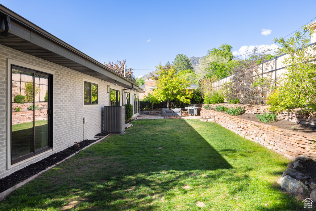 View of yard with central air condition unit and a patio