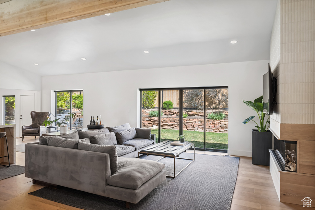 Living area featuring recessed lighting, light wood finished floors, beamed ceiling, and high vaulted ceiling