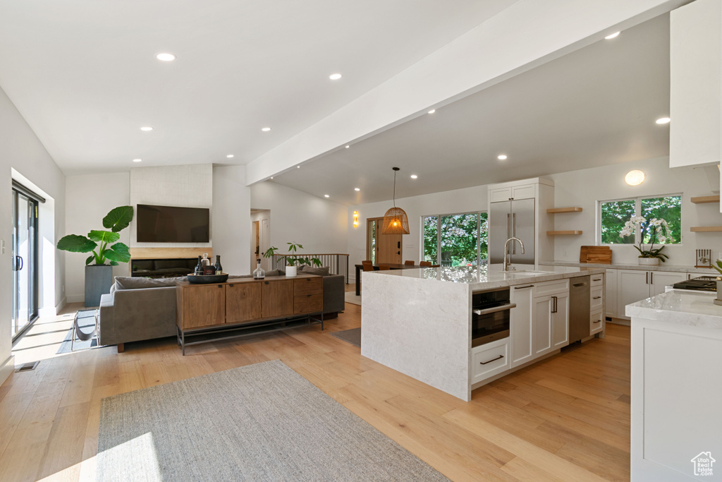 Kitchen featuring open shelves, white cabinetry, open floor plan, light wood-style floors, and recessed lighting