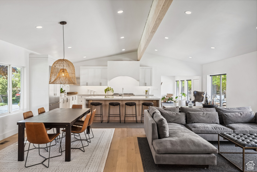 Living area featuring beam ceiling, light wood-style flooring, recessed lighting, and high vaulted ceiling