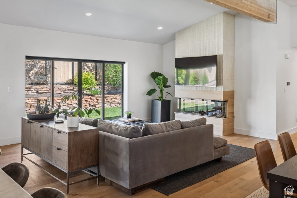 Living room with lofted ceiling, wood finished floors, baseboards, and recessed lighting