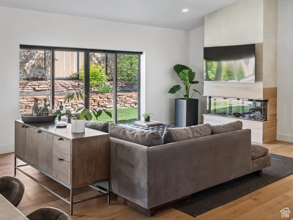 Living room with lofted ceiling, wood finished floors, baseboards, and recessed lighting