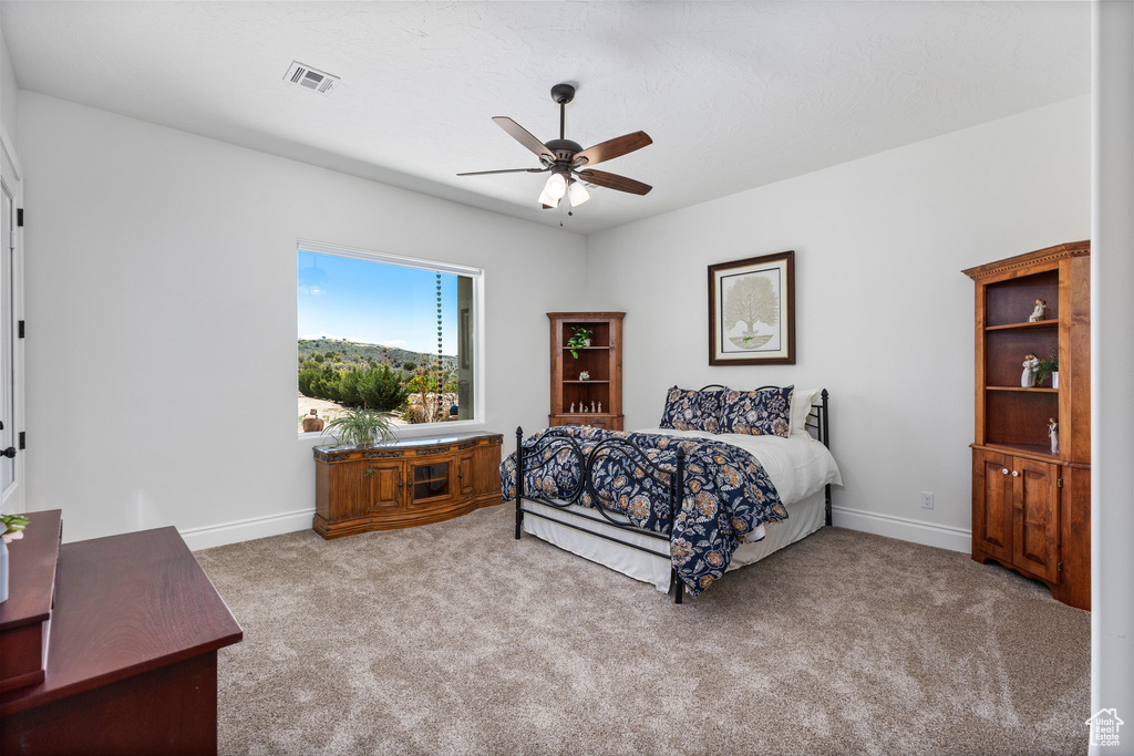 Bedroom with carpet, baseboards, and ceiling fan