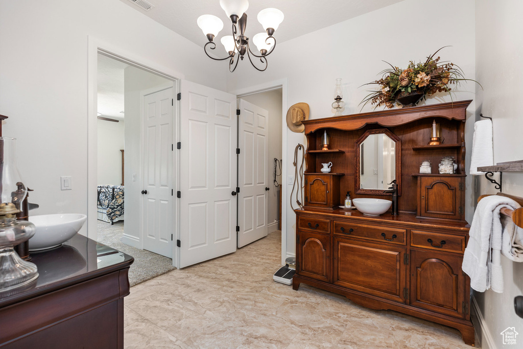 Full bathroom featuring a chandelier and vanity