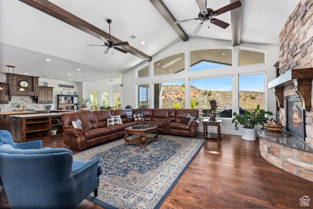 Living room with ceiling fan, beamed ceiling, a fireplace, recessed lighting, and high vaulted ceiling