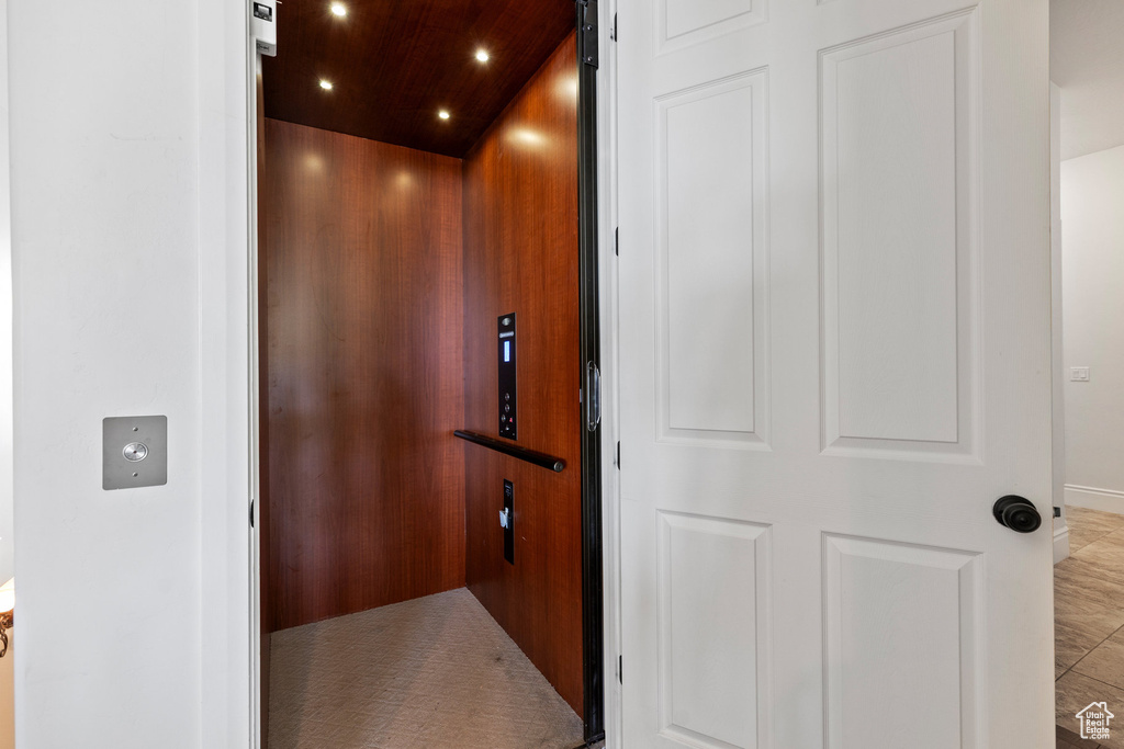 Elevator with wooden ceiling and recessed lighting