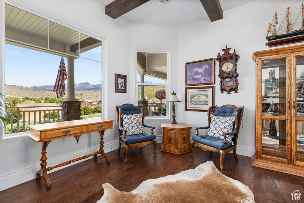Living area featuring beamed ceiling, a mountain view, hardwood / wood-style flooring, baseboards, and decorative columns