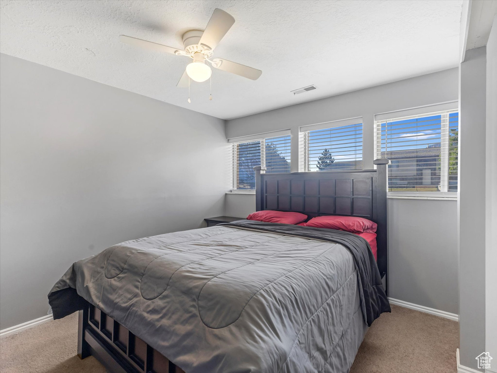 Bedroom with carpet flooring, baseboards, and ceiling fan