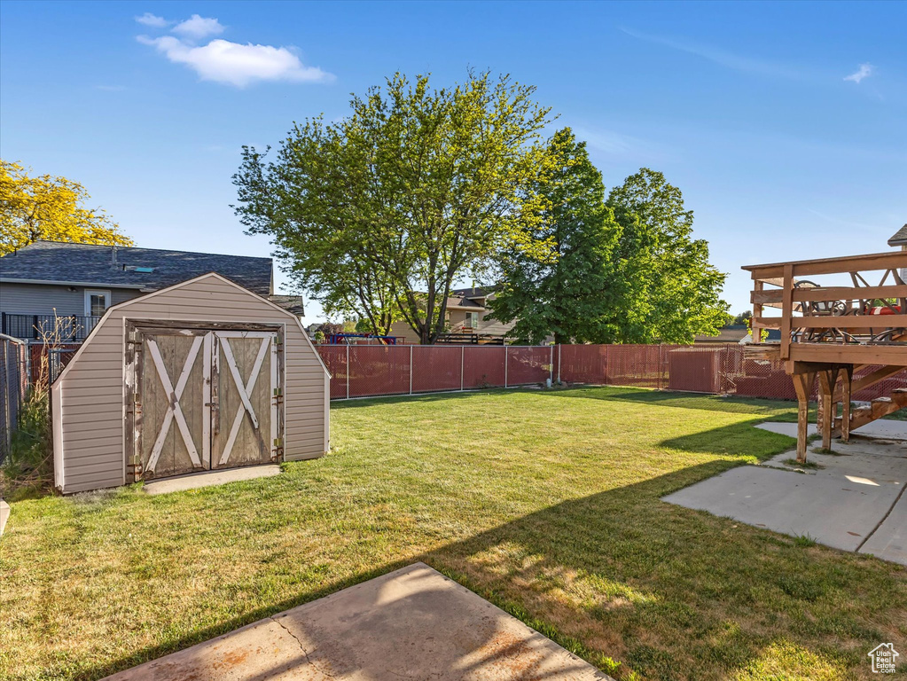 View of yard featuring a patio area, a storage shed, and an outbuilding