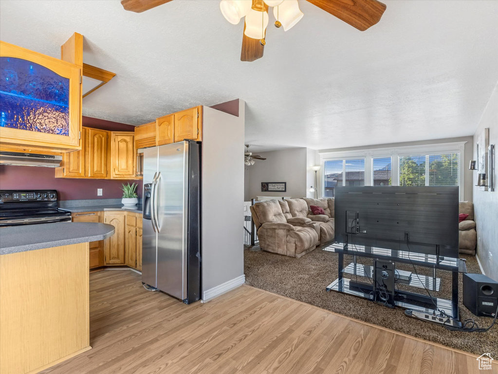 Kitchen with stainless steel fridge, electric range, a ceiling fan, open floor plan, and light wood finished floors