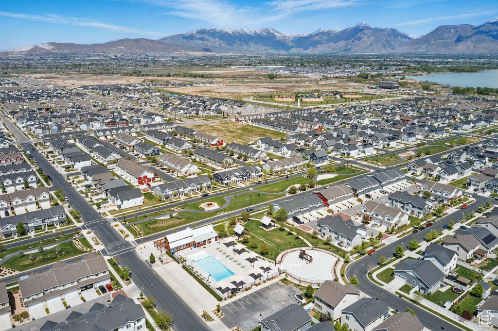 View of property location featuring a pool, nearby suburban area, and a water and mountain view