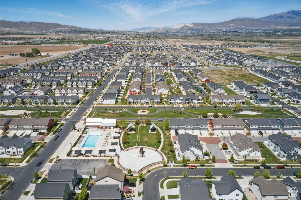 Aerial view of property\'s location featuring a mountainous background, nearby suburban area, and a pool area