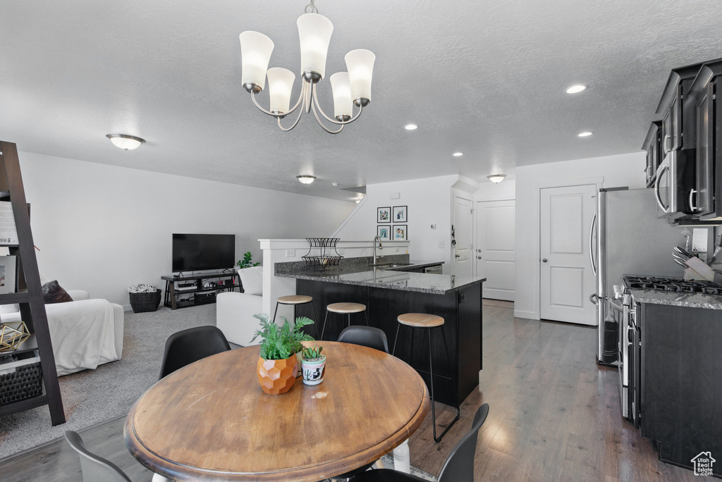 Dining area featuring dark wood finished floors, recessed lighting, and a chandelier