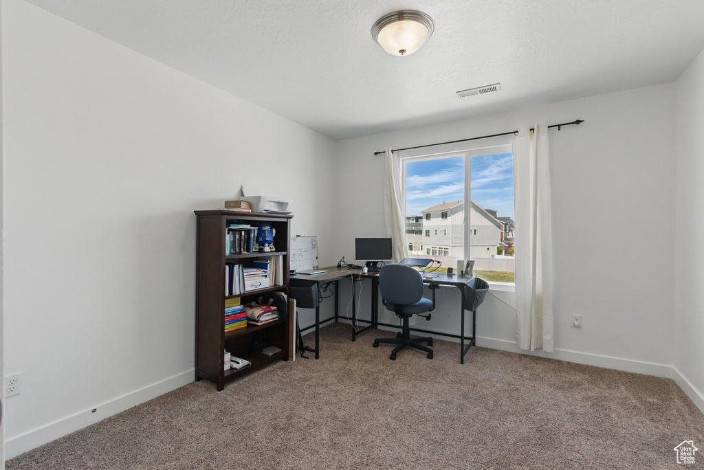 Carpeted home office featuring baseboards