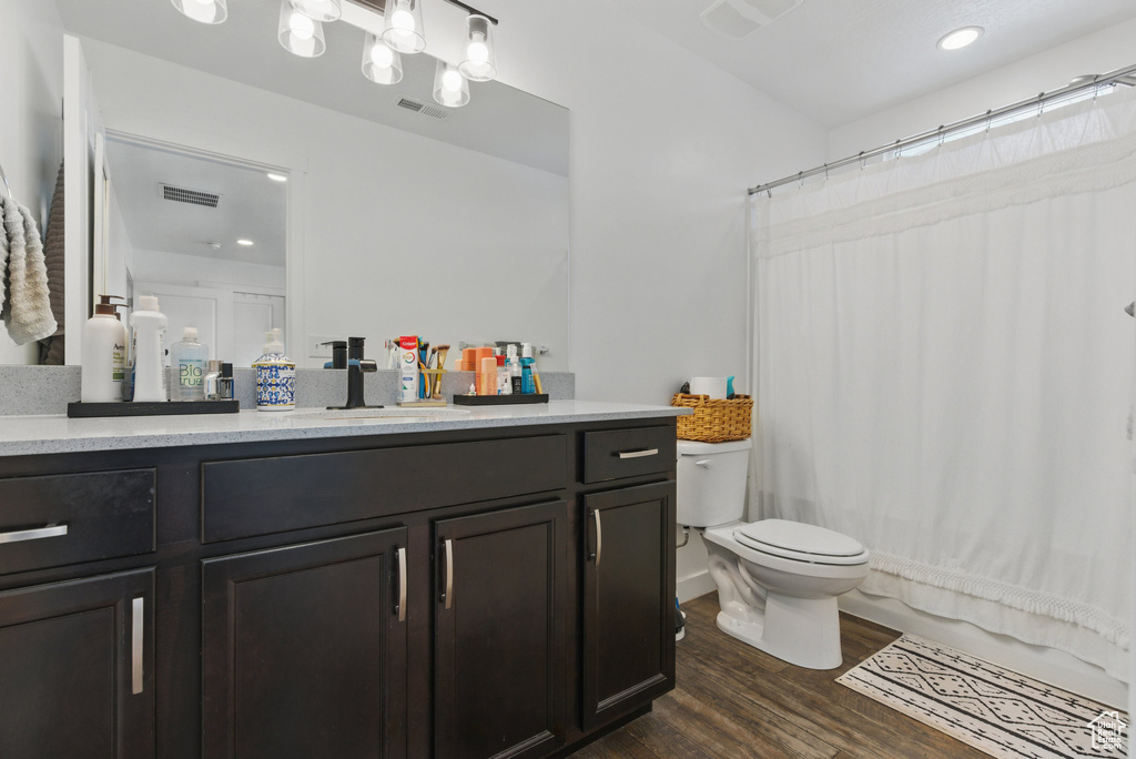 Full bathroom featuring wood finished floors, toilet, vanity, a shower with shower curtain, and recessed lighting